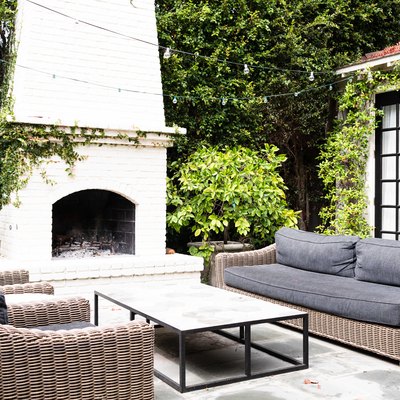 woven outdoor sofas with grey cushions and outdoor fireplace