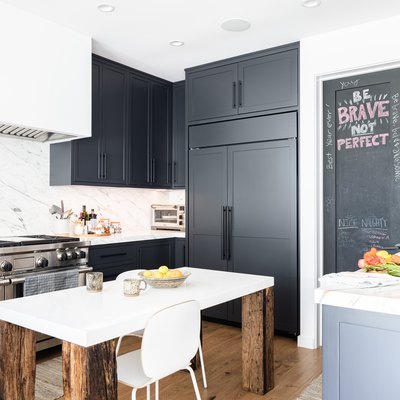 White walled kitchen with gray cabinets and wood floor
