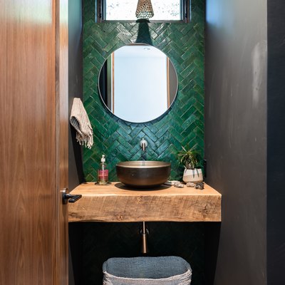 Green tiled basement bathroom idea with a wood counter and flooring with small window