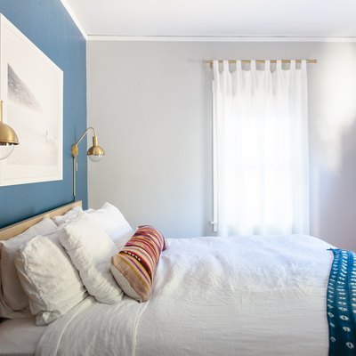 bedroom with blue wall and white curtains