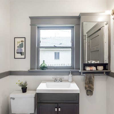 Bathroom with neutral black tile flooring, small vanity and gray accents
