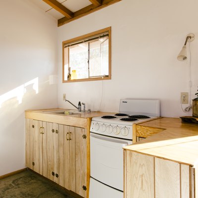 A kitchen with natural wood cabinets and an electric stove