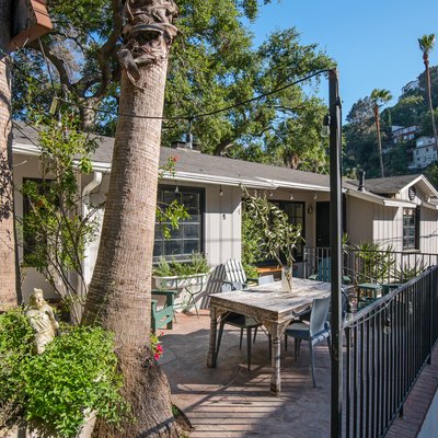 a ranch house with a metal fence surrounding the upper deck