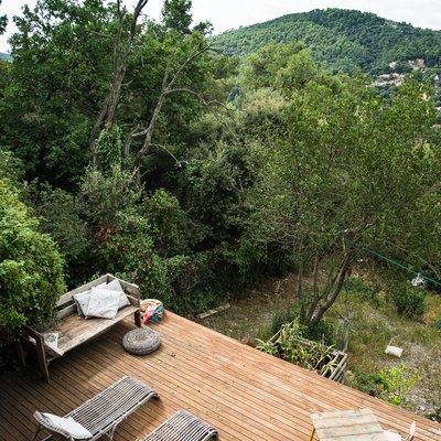 A wood deck overlooking mountains and trees with a patio furniture set