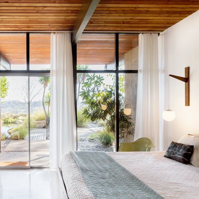Bedroom with floor to ceiling windows and white curtains