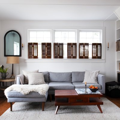 White living room with brown shutters and dark farmhouse furniture