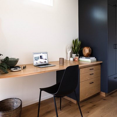 black and wood small home office idea with plants and guitar on the wall