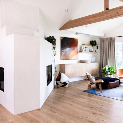 wood beam in modern white room with floating wood credenza and modern fireplace