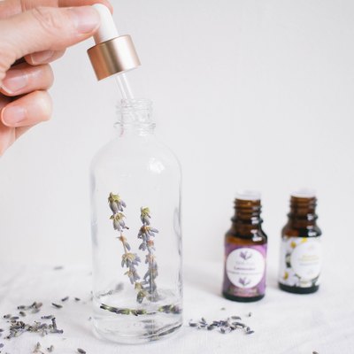 Spray bottle with herbs and essential oil bottles