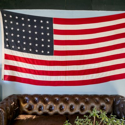 Brown leather sofa with American flag on gray wall and water cooler