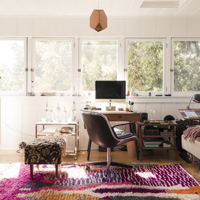white home office with desk and chair in front of windows