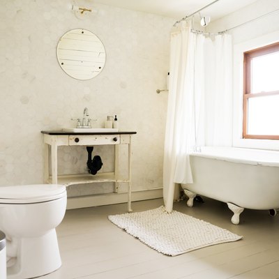 a bathroom with a rustic wooden vanity and a claw-foot tub