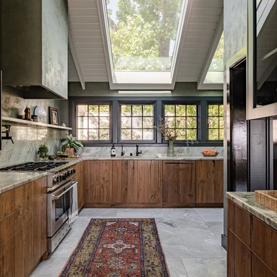 Green kitchen walls with wood cabinets, granite or marble backsplash-counters, and skylights.