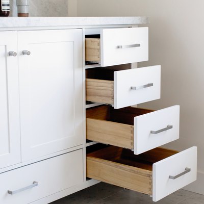 white bathroom vanity with four open drawers