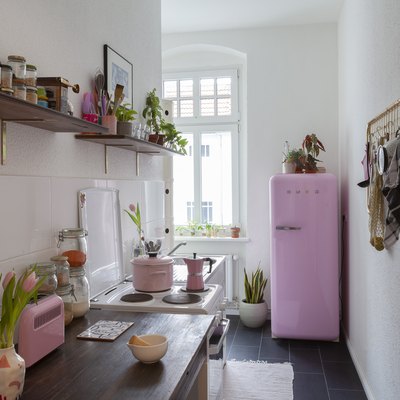 small narrow kitchen with pink smeg fridge