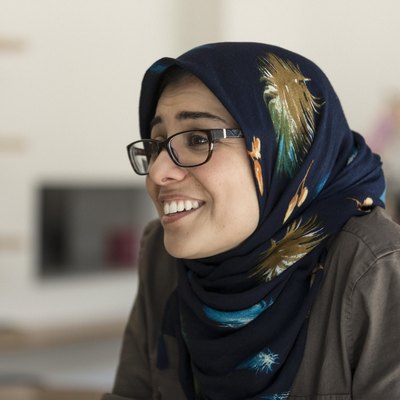 maryam eskandari smiling, wearing glasses and a headscarf