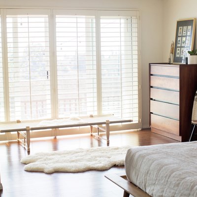 A light and bright bedroom with blinds over the windows