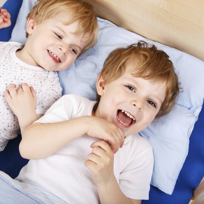Two little toddler boys having fun and fighting