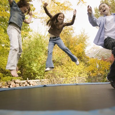 Siblings jumping on trampoline
