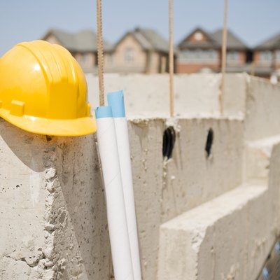 Construction Hat, New Home Foundation and Blueprints