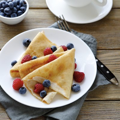 summer crepes with berries on white plates