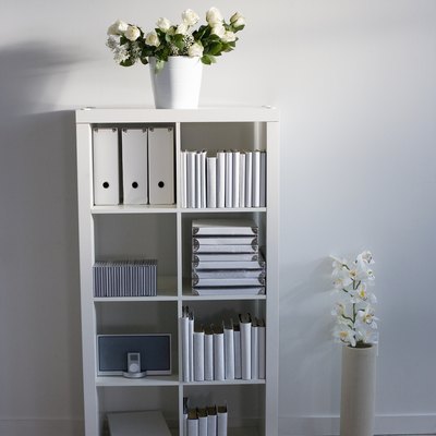 Bookcase and bouquets in sparse home office