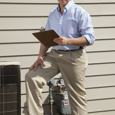 Man with clipboard standing near air conditioning unit