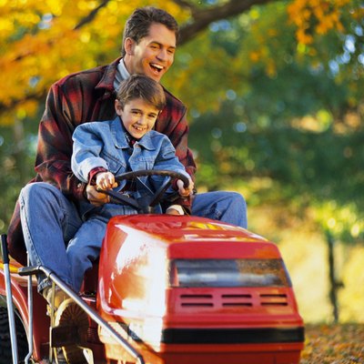 Father and son on tractor mower