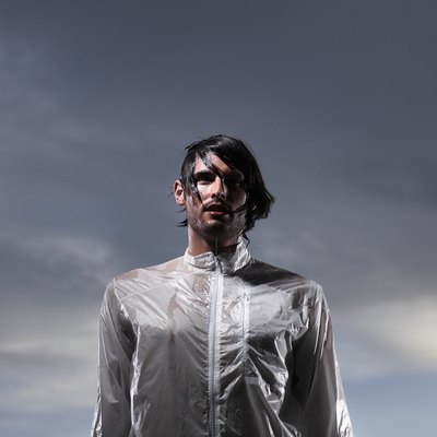 Drenched young man at dusk, low angle view