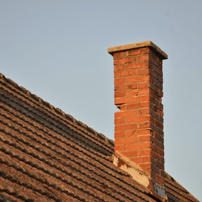 Orange roof tiles, brick chimney and blue sky
