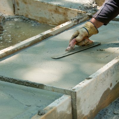 Construction worker smoothing wet concrete with trowel