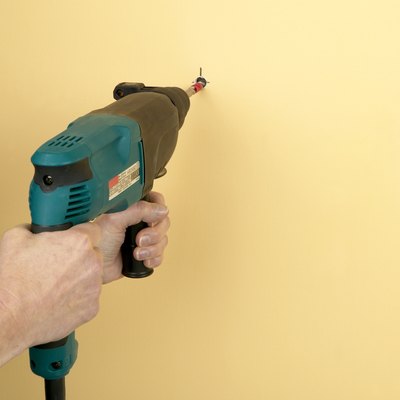 Man using drill to make hole in wall