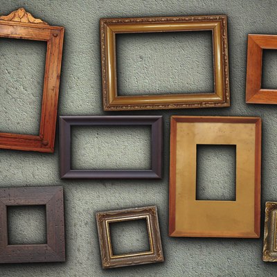 lots of picture frames hung on green wall