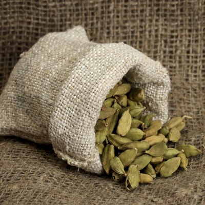 Green cardamom in sack on canvas background