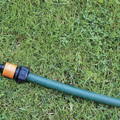 Hose on grass, Clover and Dandelion leaves, close-up