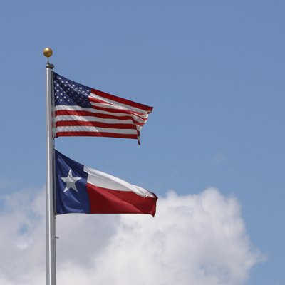 American flag and state flag of Texas in sky
