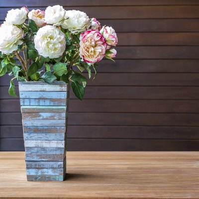 Artificial flowers with rustic wooden vase in modern interior room