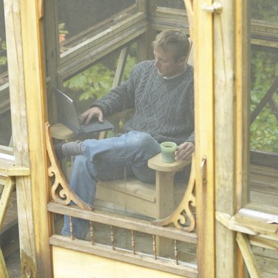 Man relaxing on porch with laptop computer