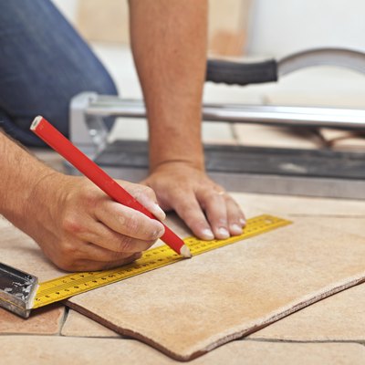 Laying ceramic floor tiles - man hands closeup