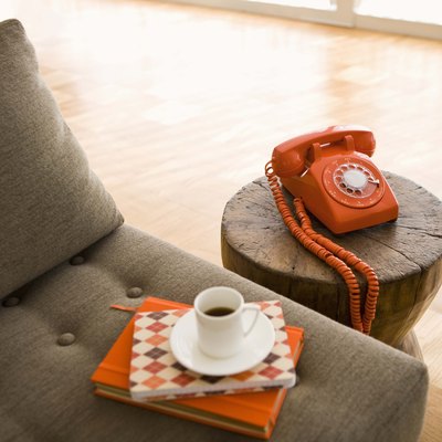 Rotary telephone and cup of coffee on sofa