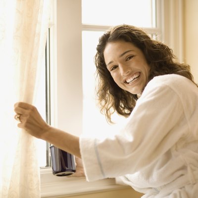 Woman with coffee near window