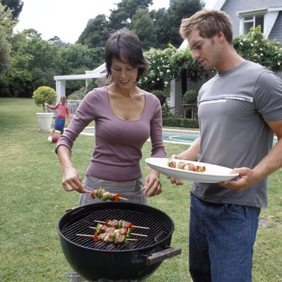 Parents at grill while are playing
