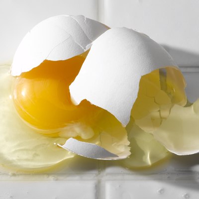 Broken egg on white tiles