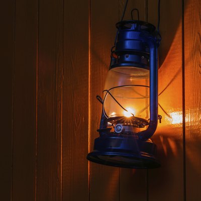 old kerosene lantern hanging on the yellow wooden wall