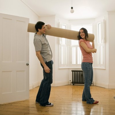 Couple carrying carpet roll