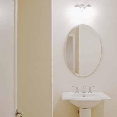 Pedestal sink and mirror in bathroom
