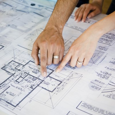 Couple pointing to blueprints