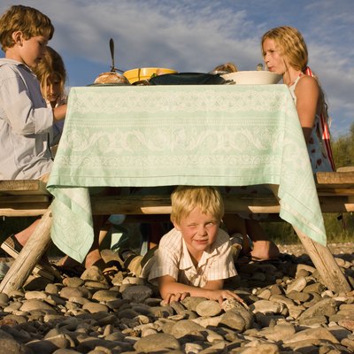 Boy hiding under outdoor table