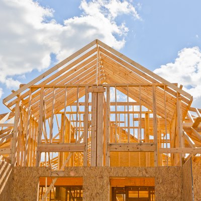 New residential construction home framing against a blue sky