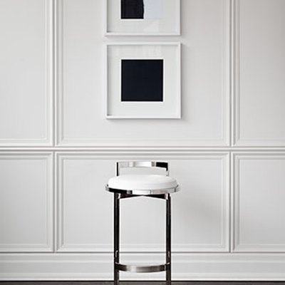 white wainscoted wall with silver barstool pictured